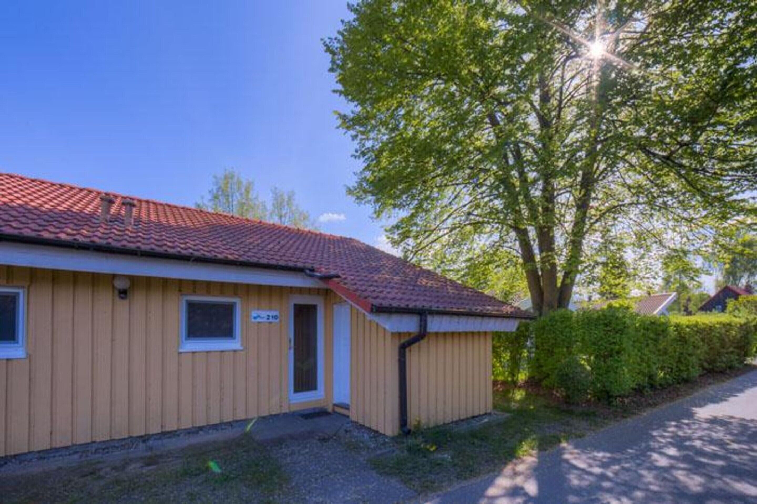 A small building with a red-tiled roof, a door, and a window.
