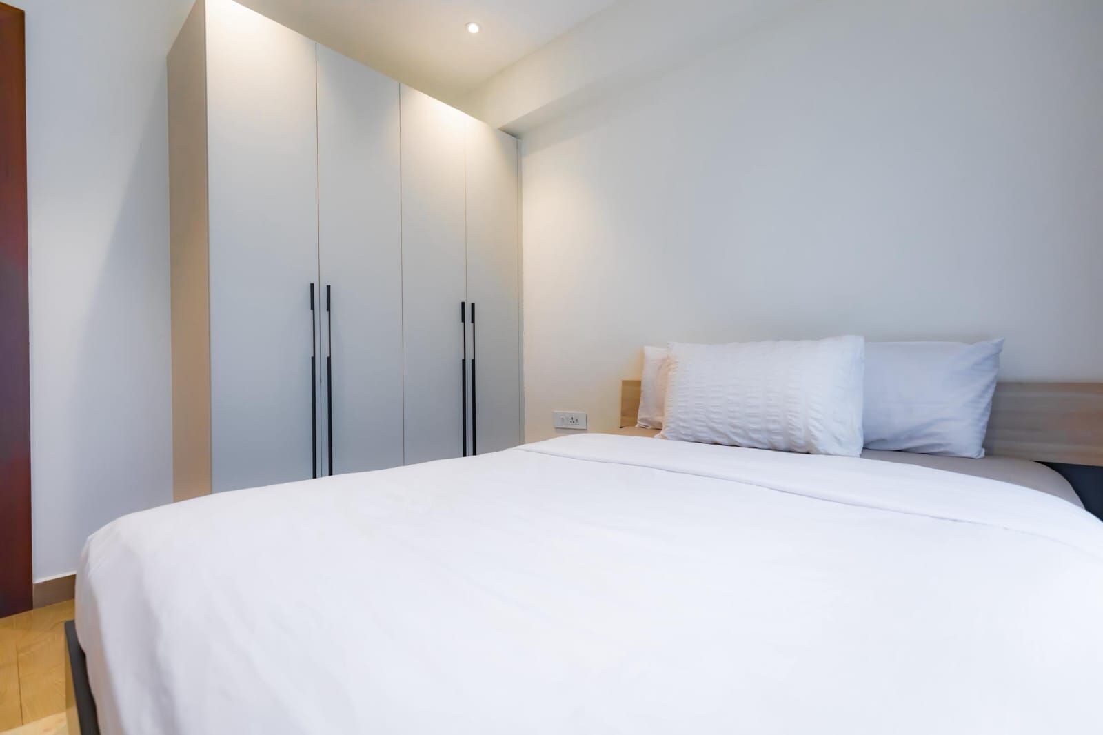 Une chambre à coucher avec un lit, une armoire et une table de chevet.