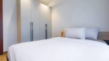 Une chambre à coucher avec un lit, une armoire et une table de chevet.