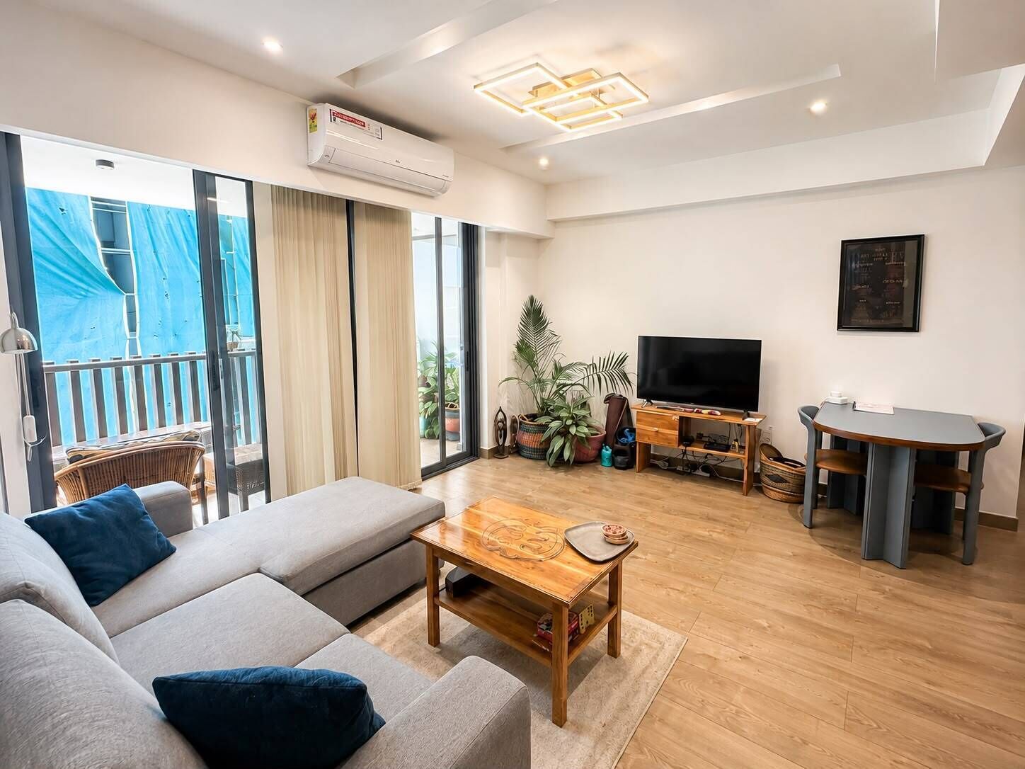 Una sala moderna con sofá, mesa de centro, televisor y comedor.