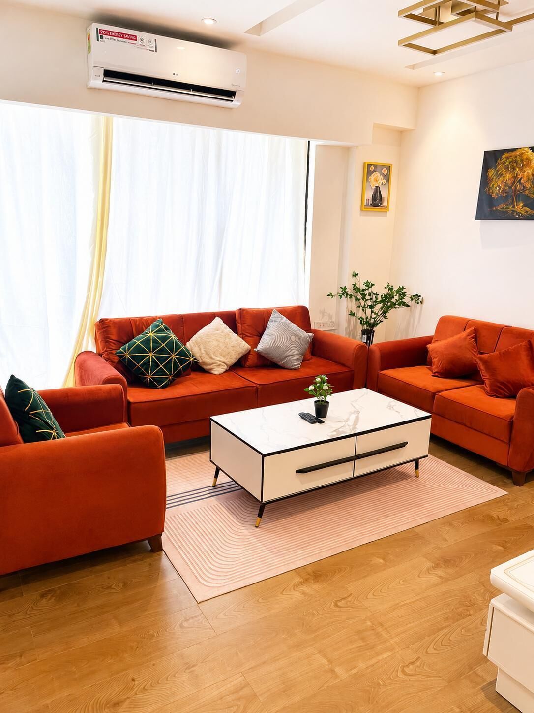 Una sala moderna con un conjunto de sofá, una mesa de centro y un equipo de aire acondicionado.