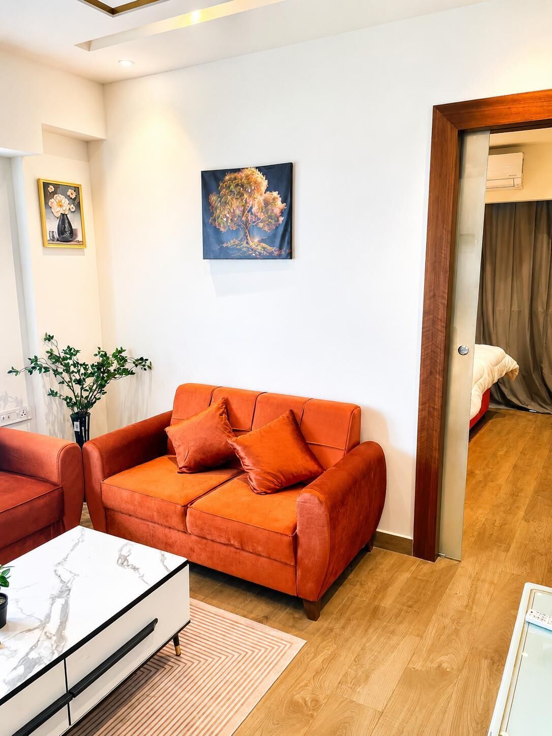 Una sala de estar con un sofá, una mesa de centro y un cuadro en la pared.
