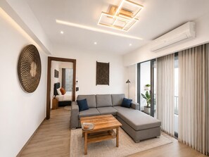 A modern living room with a sectional sofa, a wooden coffee table, and a large window with curtains. - Solaris  (Accra)