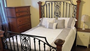 A bedroom with a wooden bed, a nightstand, a dresser, and a ceiling fan. - A wonderful modern home… (New Orleans)