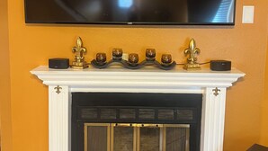 A fireplace with a flat-screen TV mounted above it. - A wonderful modern home… (New Orleans)