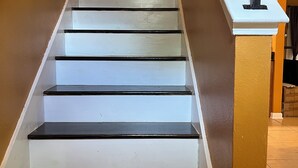 A staircase with white steps and black edges, leading to a landing with a white balustrade. - A wonderful modern home… (New Orleans)