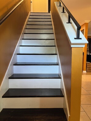 A staircase with white steps and black edges, leading to a landing with a white balustrade. - A wonderful modern home… (New Orleans)