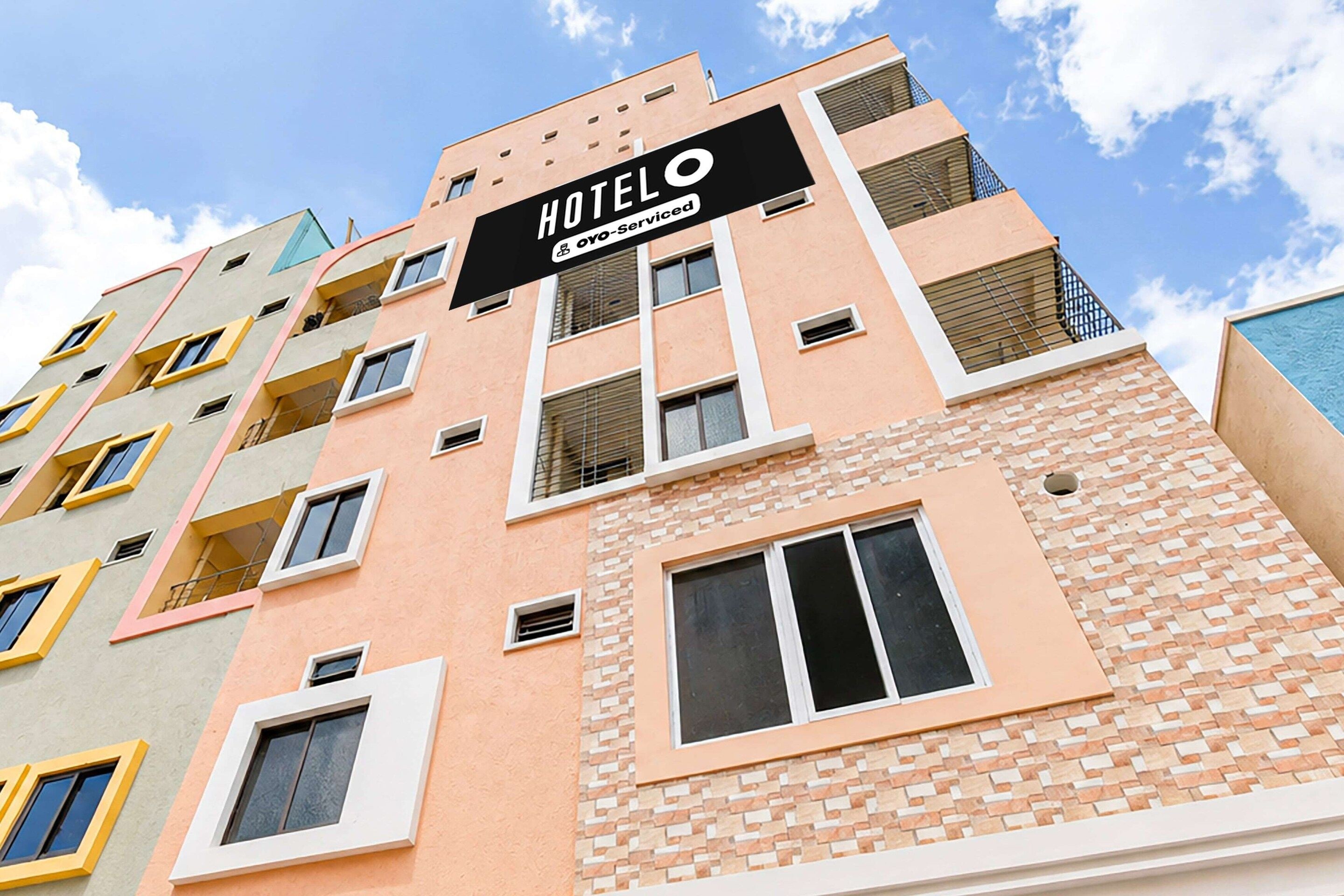 Un immeuble hôtelier à plusieurs étages, doté d’une enseigne bien visible indiquant qu’il est exploité par OYO.