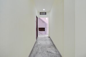 A corridor with a marble floor leading to a staircase. - Classic SLN Terminus Gachibowli (Hyderabad)