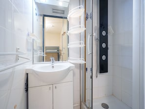 A bathroom with a sink, mirror, and shower. - Cabin apartment with a loggia offering sea views (Agde)