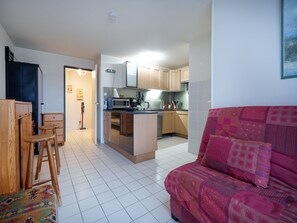 A compact living space with a kitchenette, a sofa, and a dining area. - Cabin apartment with a loggia offering sea views (Agde)