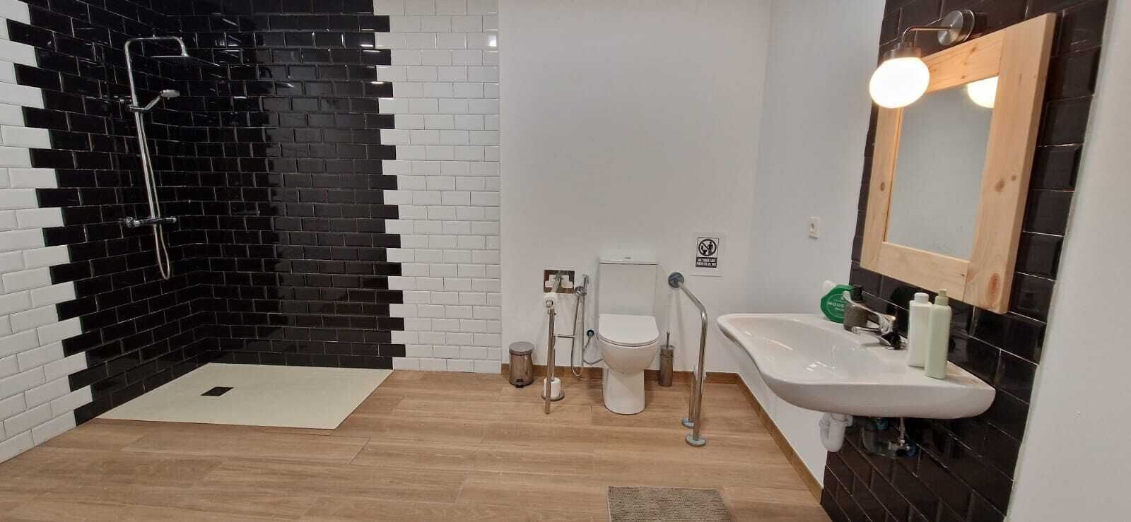 Een douche, een bidet, handdoeken, toiletpapier