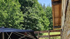 An outdoor patio with a table and chairs, a wooden door, and a stone wall. - Jentilbaratze: More Than Just a Country House. Multifunctional space surrounded by nature (Orozko)