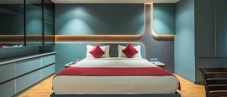 A modern bedroom with a bed, bedside tables, a desk, and a chair.
