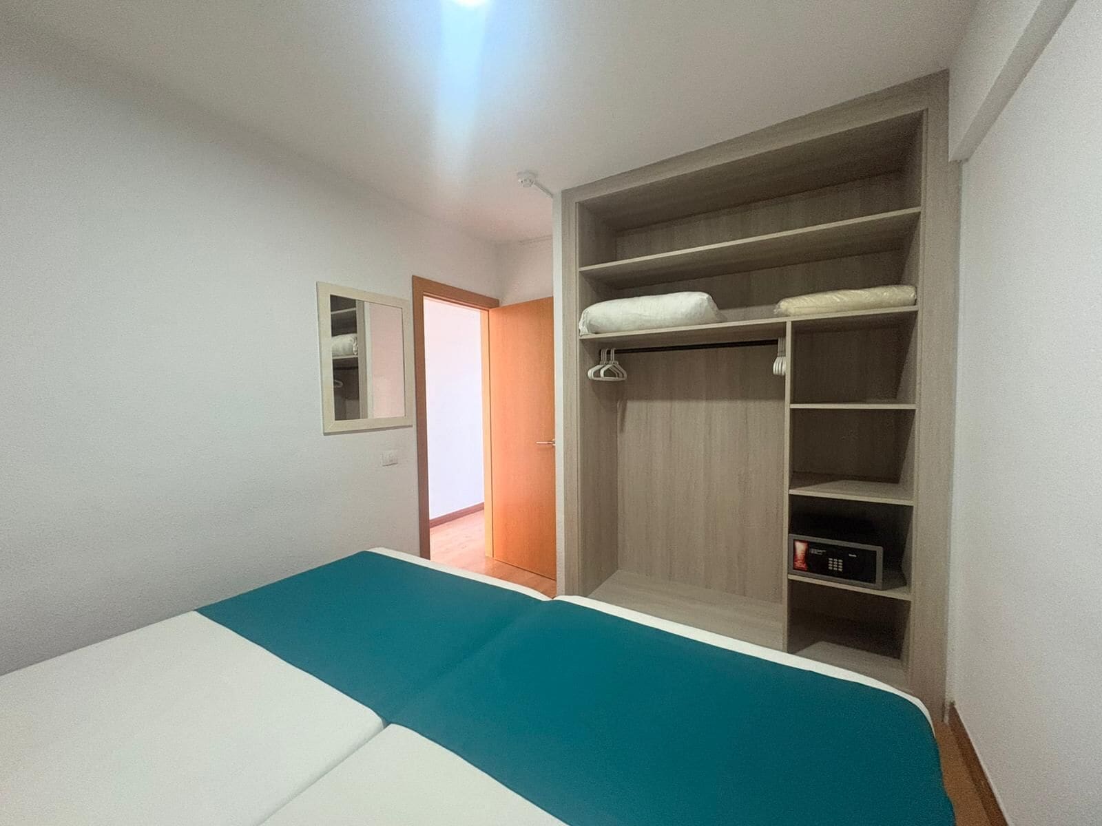 Une chambre à coucher avec un lit, une armoire et un petit placard.