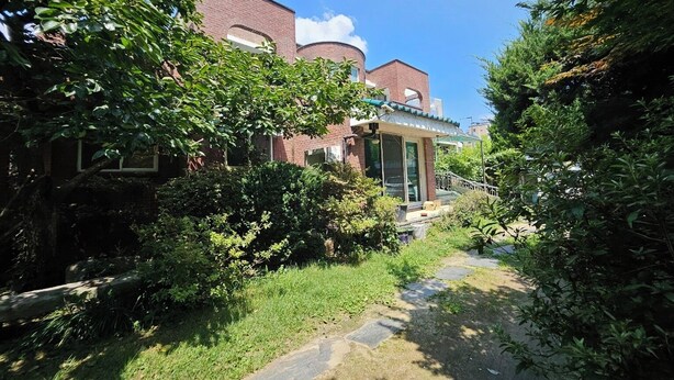 Een bakstenen gebouw met een overdekte veranda en een pad ernaartoe.