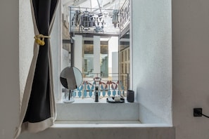 Ein Badezimmer mit Fenster, Spiegel, Handtuch und Waschbecken.