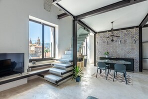 Ein modernes Interieur mit Essbereich, Wendeltreppe und Blick auf die Außenwelt.
