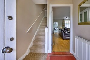 A staircase leading to a living area with a sofa and a mirror. - Artro View (Llanbedr)