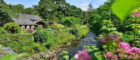 Una casa con jardín y arroyo.