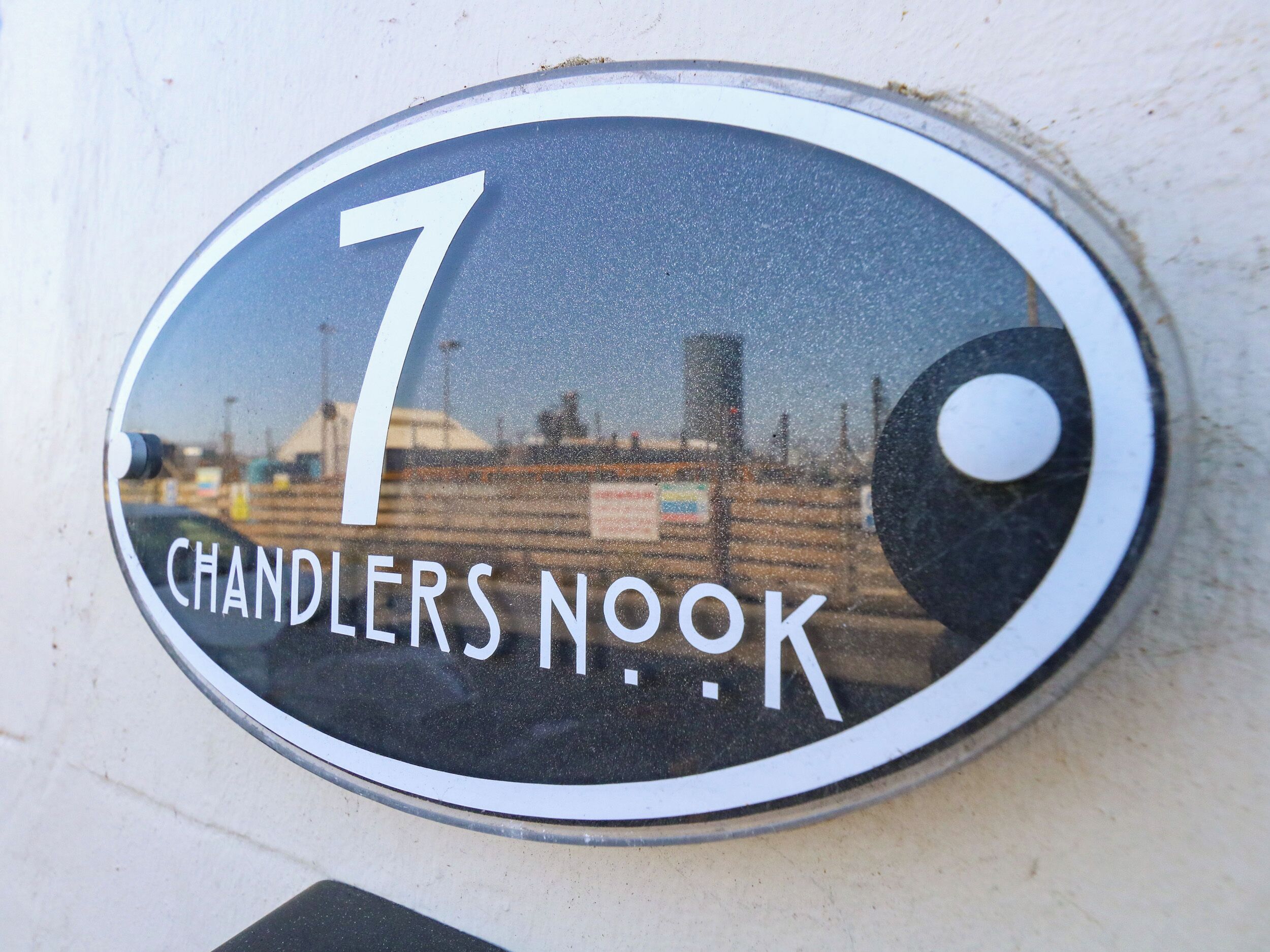 Un cartel de número de casa con el número 7 y la inscripción 'CHANDLERS NOOK' en un edificio.
