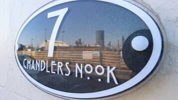 Un cartel de número de casa con el número 7 y la inscripción 'CHANDLERS NOOK' en un edificio.