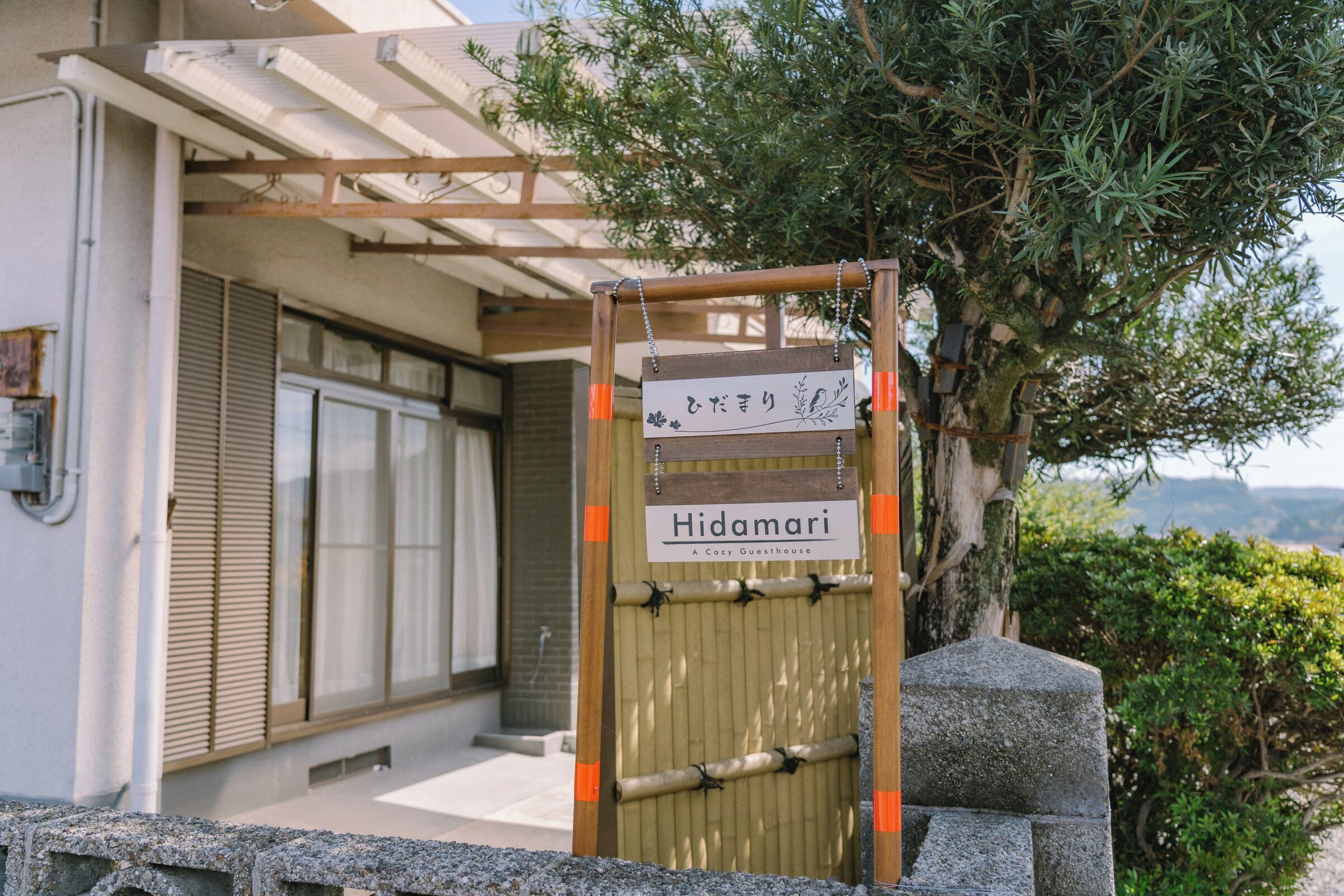 A wooden gate with a sign reading 'Hidamari' and a bamboo gate.