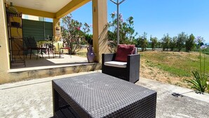 An outdoor patio with wicker furniture, a table, and a chair. - Just 30 minutes from the river, a countryside vacation rental with a view of Mont Ventoux! (Piolenc)