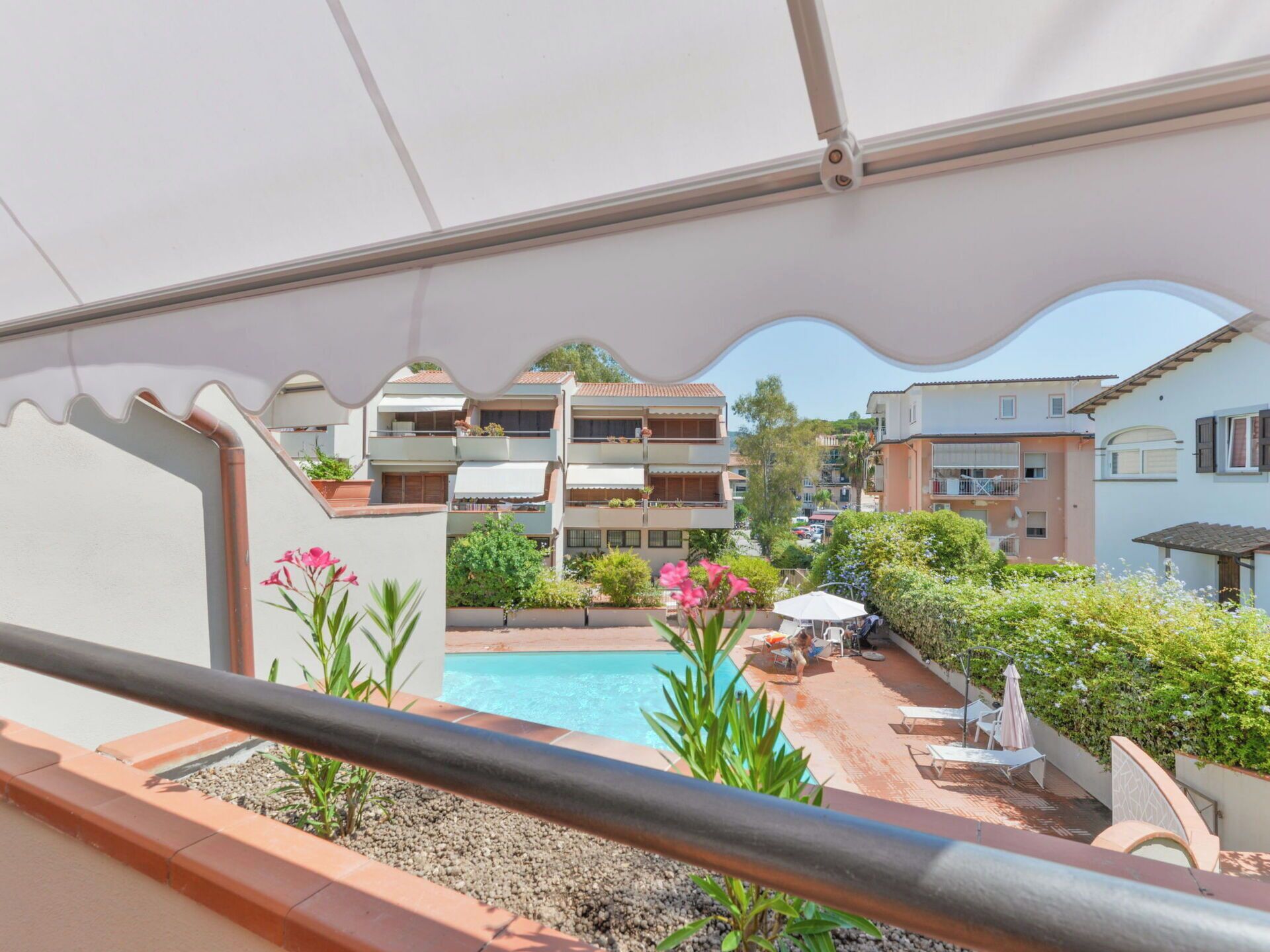 A residential building with a pool, outdoor seating, and a view of neighboring buildings.