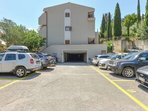 Ein Parkplatz mit mehreren Autos und einem Gebäude mit einer Garageneinfahrt.