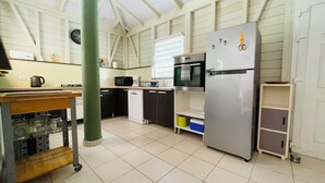 A kitchen with a stainless steel refrigerator, a microwave, a coffee maker, and a sink.