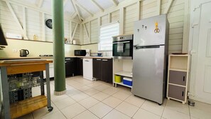 A kitchen with a stainless steel refrigerator, a microwave, a coffee maker, and a sink.