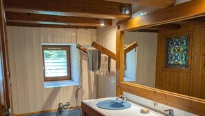A bathroom with two sinks, a window, a mirror, and a checkered floor.