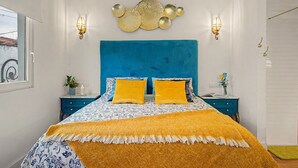 Ein Schlafzimmer mit einem Bett, Nachttischen, Wandleuchten und einem Wanddekor.