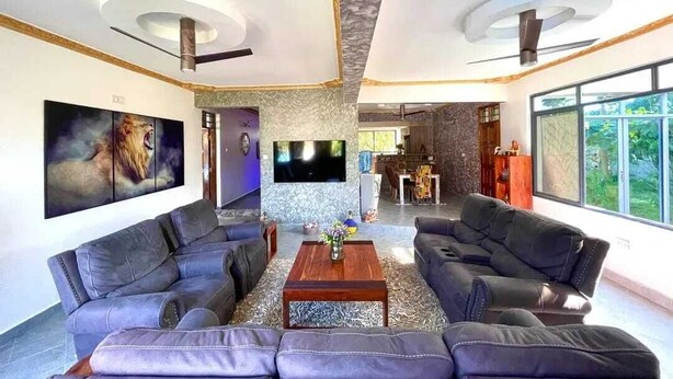 Un salón espacioso con chimenea, televisor de pantalla plana y un gran ventanal.
