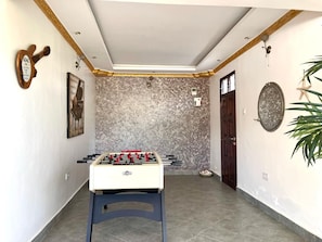 A room with a foosball table, a door, and a wall-mounted light fixture. - Spacious 6-bedroom villa in Diani with a swimming pool and access to the beach (Kwale County)