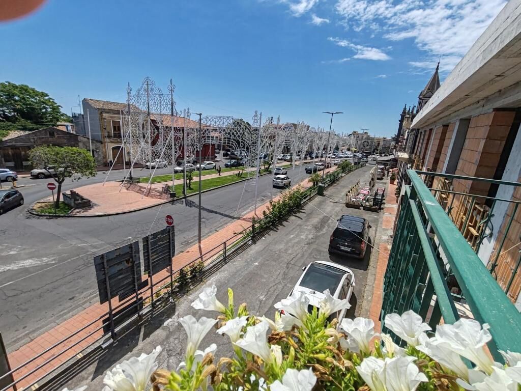 Vista de la calle con edificios, coches y una señal de parada.