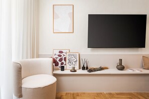 Deluxe appartement | Woonruimte | Een 55-inch smart-tv met satellietzenders