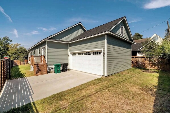 A two-story house with a garage, a deck, and a fenced yard.