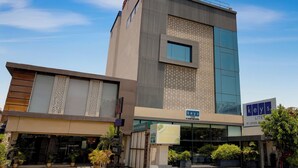 Un hotel moderno con un letrero que dice 'Keys Lite' y otro letrero que indica 'Restaurante Vegetariano Zucchini'.