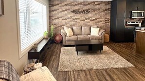 Ein modernes Wohnzimmer mit einer Couch, einem Couchtisch und einem Kamin.