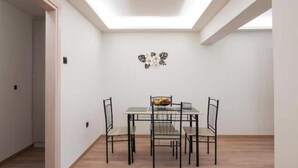 Ein Essbereich mit Tisch und Stühlen, einer Wanddekoration und einem Oberlicht.