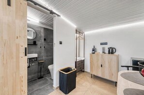 A modern bathroom with a wooden cabinet, a sink, and a toilet. - Loft Studio with Sea View | Modern Comfort Near Glyfada Beach & City Center (Glyfada)