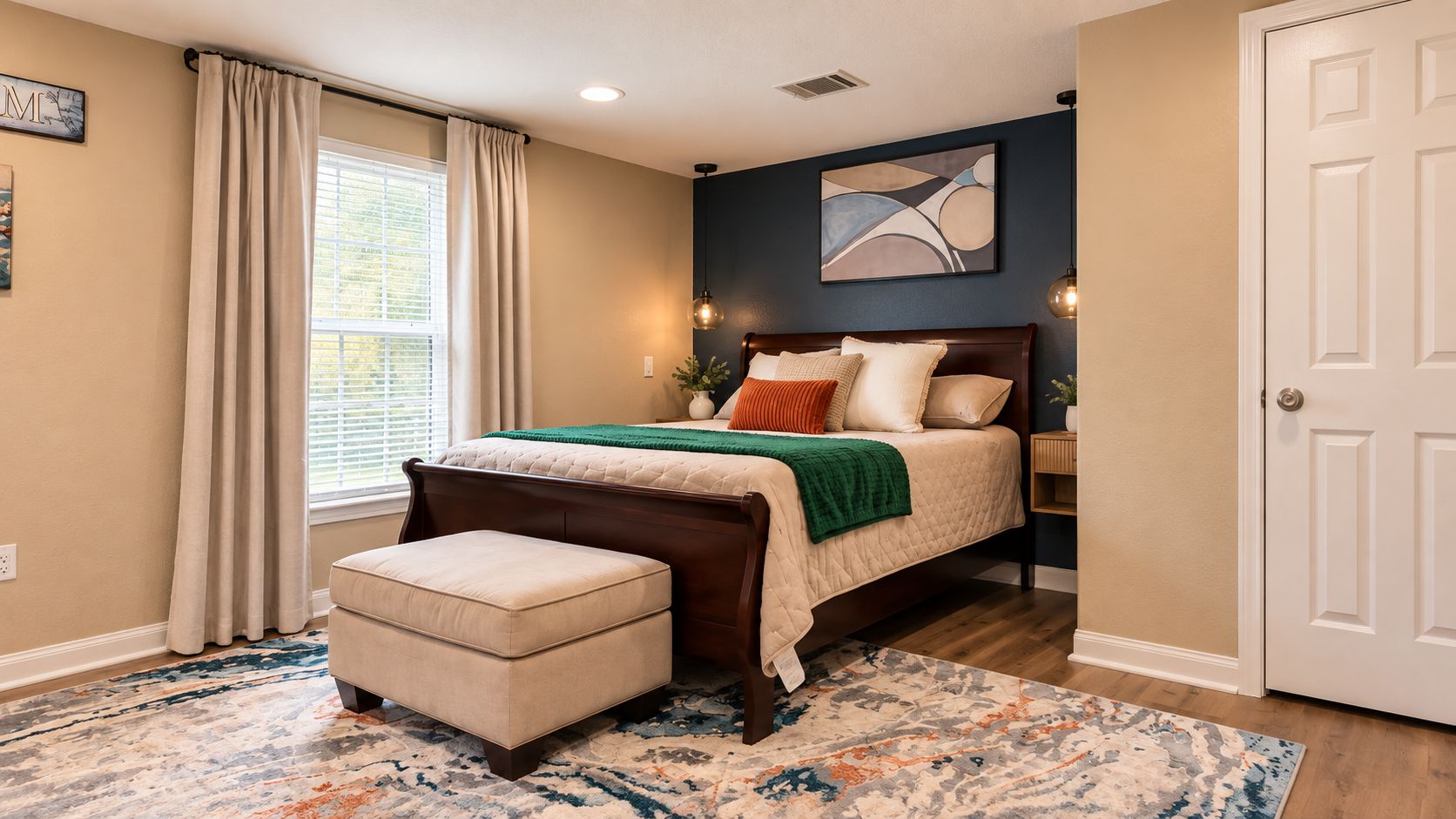 Cozy designer bedroom with king bed, accent wall, and sunny window
