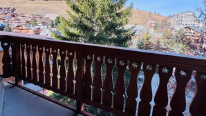 Un balcon donnant sur une ville, avec vue sur les bâtiments et une montagne.