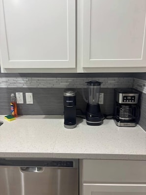 A kitchen with a dishwasher, a Keurig coffee maker, a blender, and a coffee maker. - 2BR/2BA Near NRG, Galleria & Memorial City (Houston)