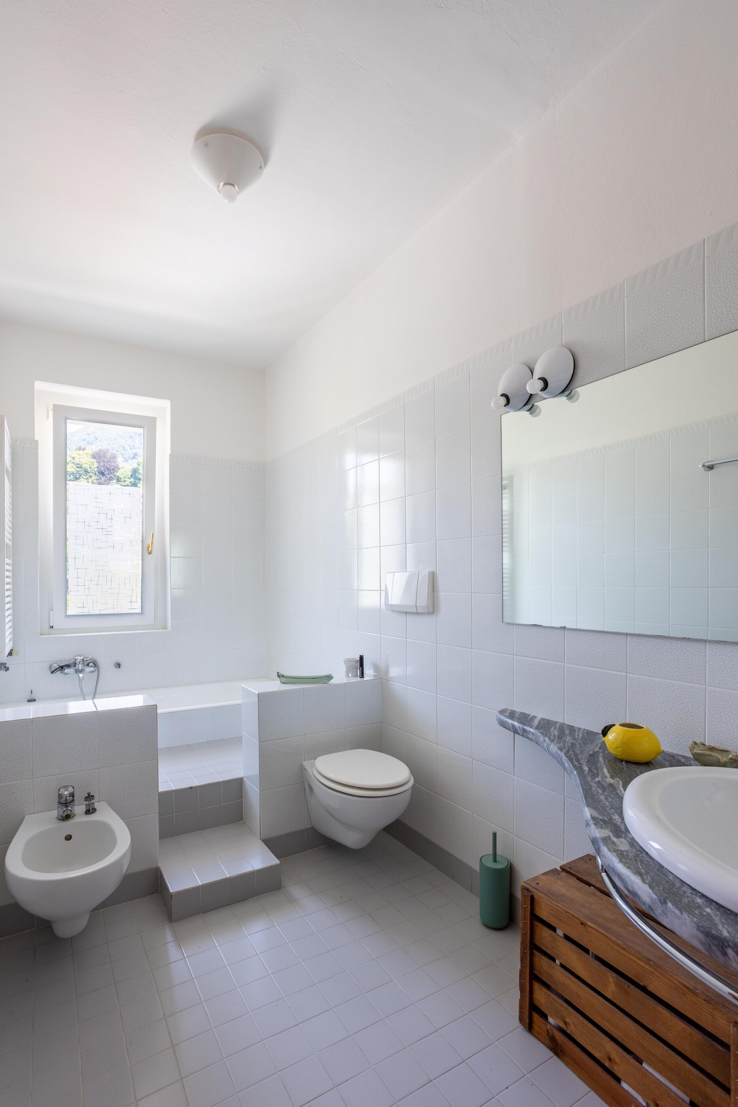 Une salle de bain moderne équipée d’une baignoire, de toilettes, d’un bidet et d’un lavabo.
