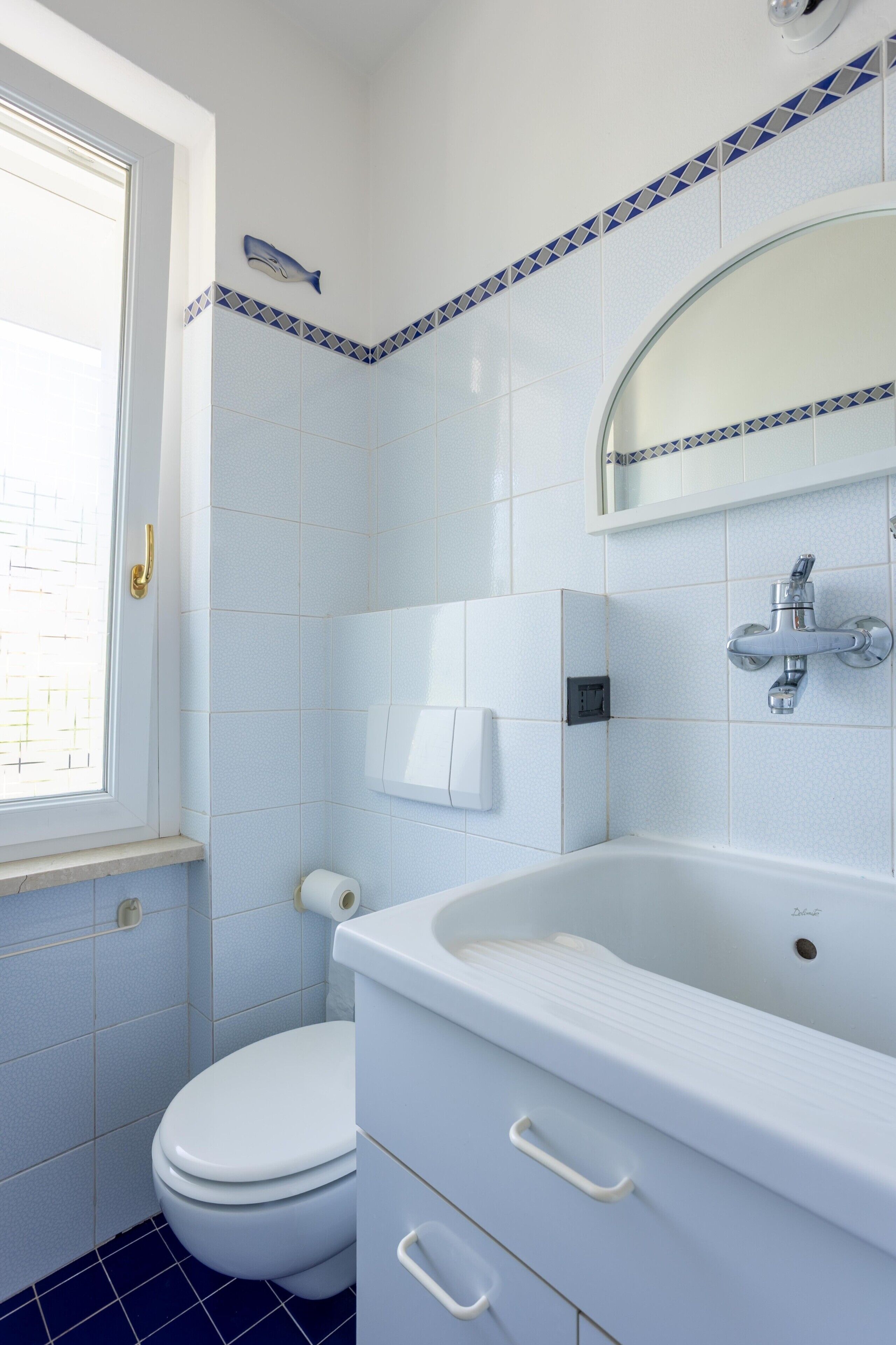 Ein Badezimmer mit Toilette, Waschbecken und Spiegel.