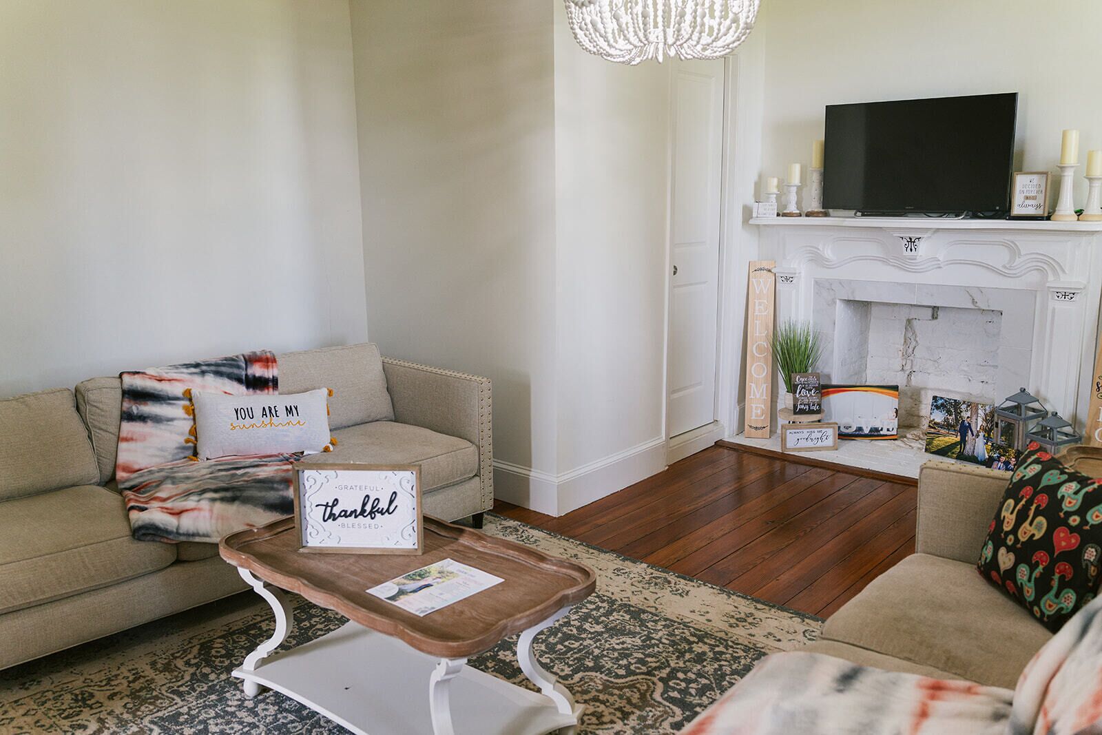 A living room with a sofa, a coffee table, a fireplace, and a television.