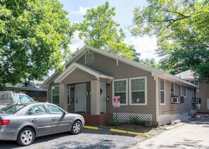 A single-story building with a front porch, a garage, and a driveway. - Pet-Friendly Houston Apartment w\ Backyard (Houston)